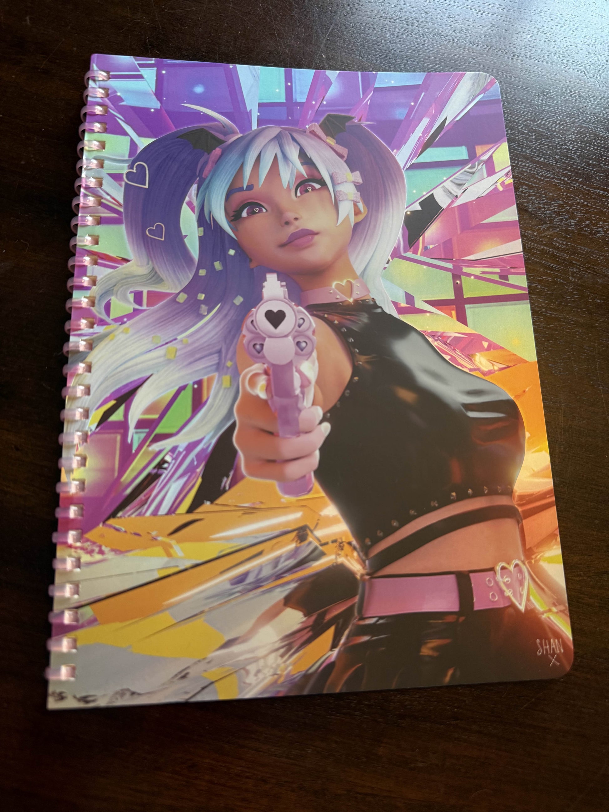 Bad Vibes holographic spiral notebook featuring anime girl pointing pink heart gun on iridescent geometric cover
