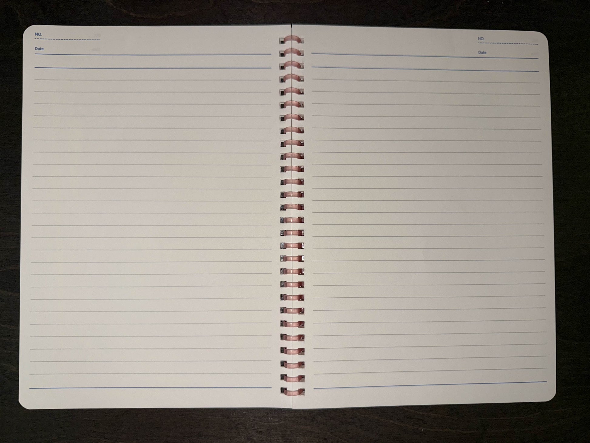 Bad Vibes holographic spiral notebook open to blank ruled two page spread with pink coil