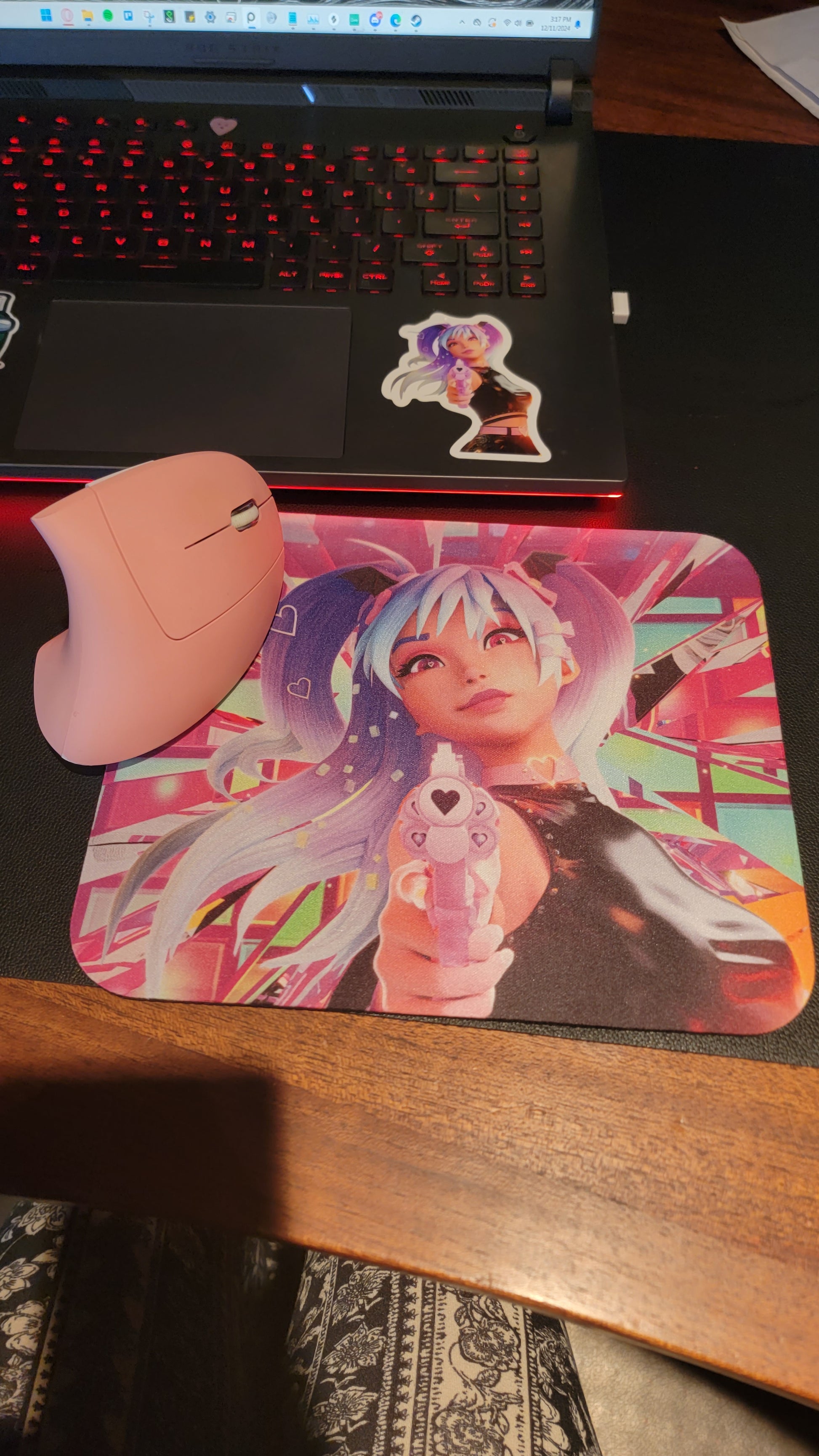 Printify cyberpunk anime mouse pad featuring pink haired futuristic girl pointing a blaster next to a pink mouse on a laptop desk