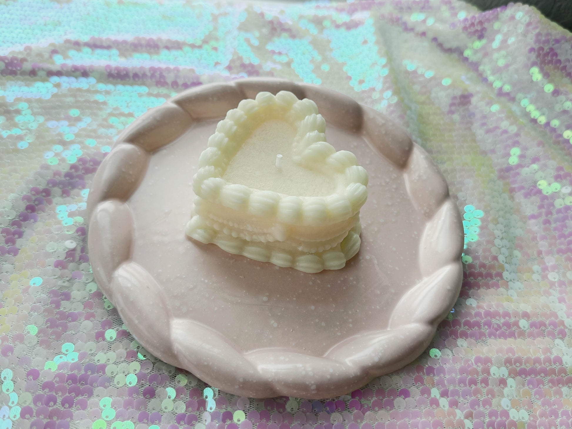 Bad Vibes vintage coquette cake candle ivory heart shaped layered cake on pink braided rim plate with sequin backdrop